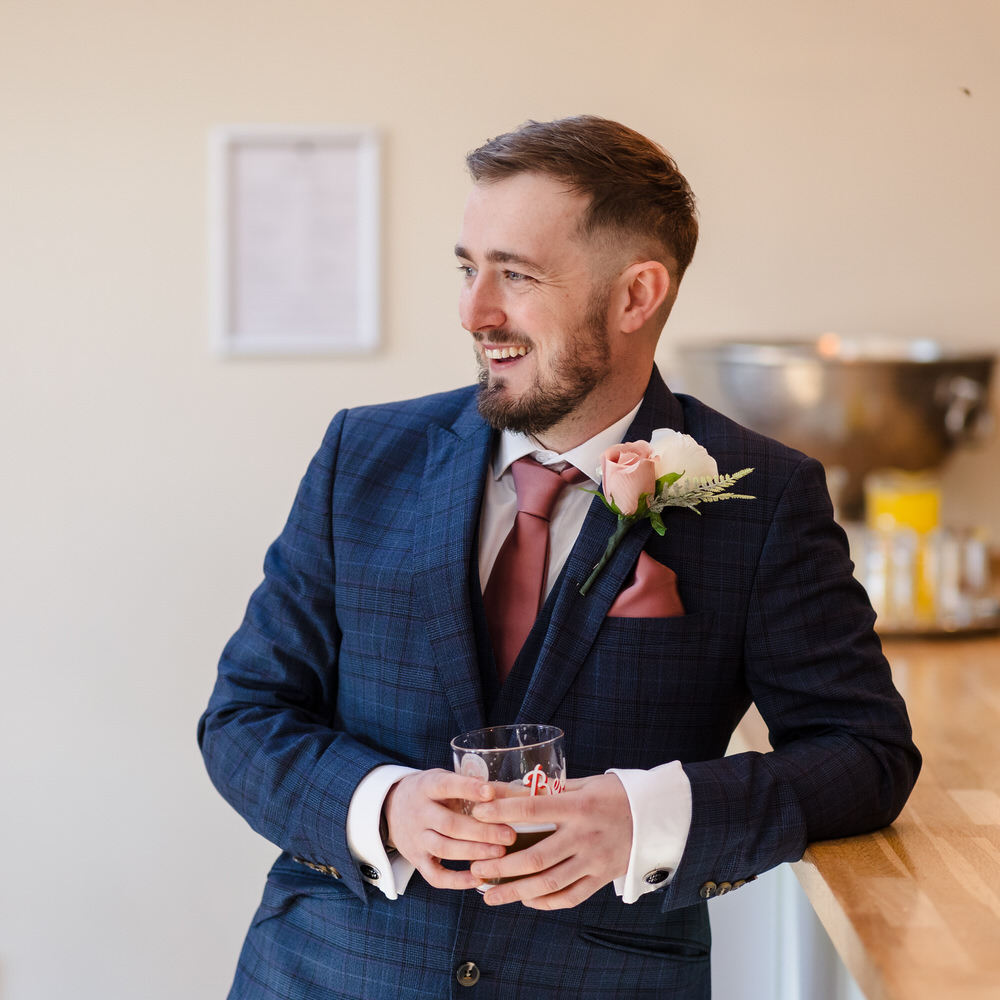 Candid moment of a groom relaxing during wedding morning preparations