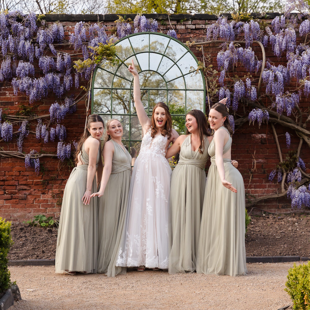 Joyful bride and bridesmaids in a beautiful garden setting