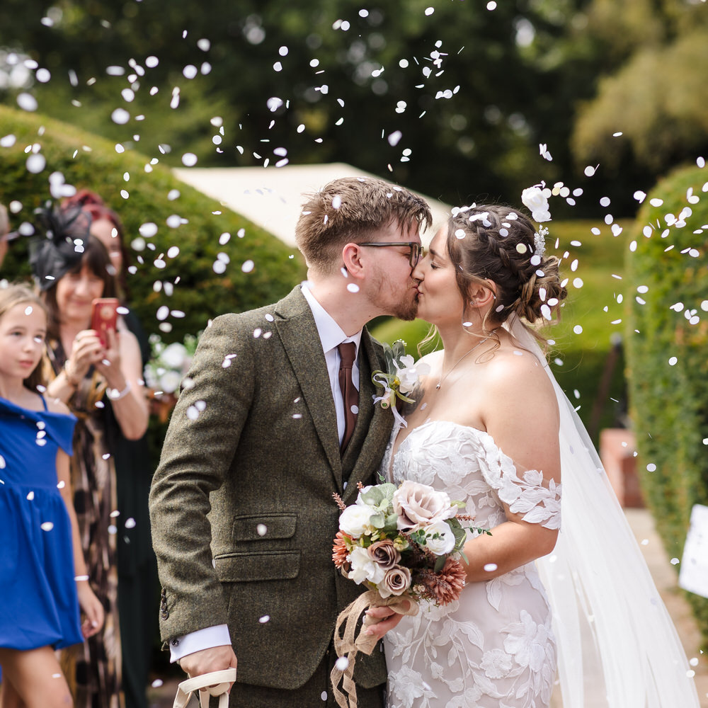 Confetti moment as a couple kiss after their Worcestershire wedding ceremony