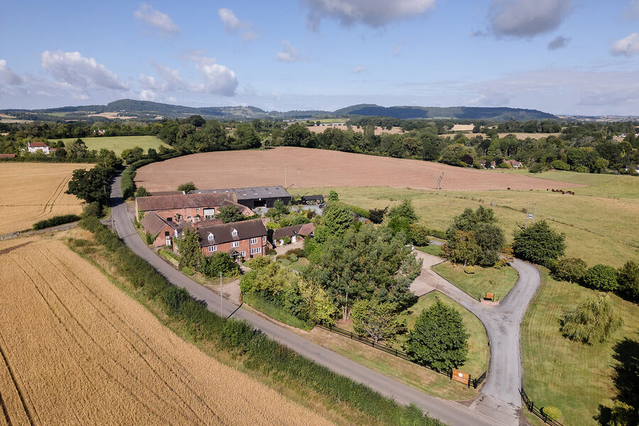Aerial view of Curradine Barns wedding venue in Shrawley, Worcestershire, with the Malvern Hills visible in the distance