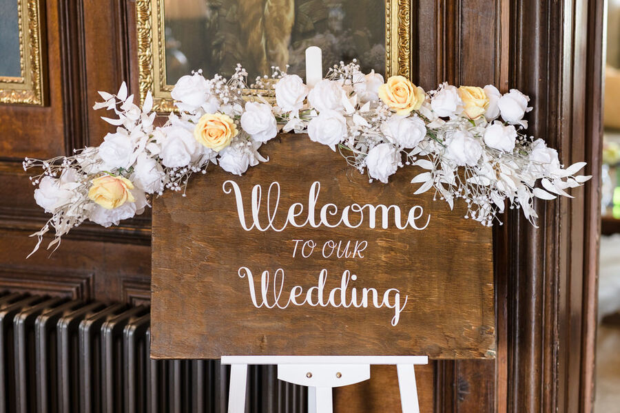 Wedding welcome sign with white and yellow roses inside Rowton Castle — venue detail on the wedding day